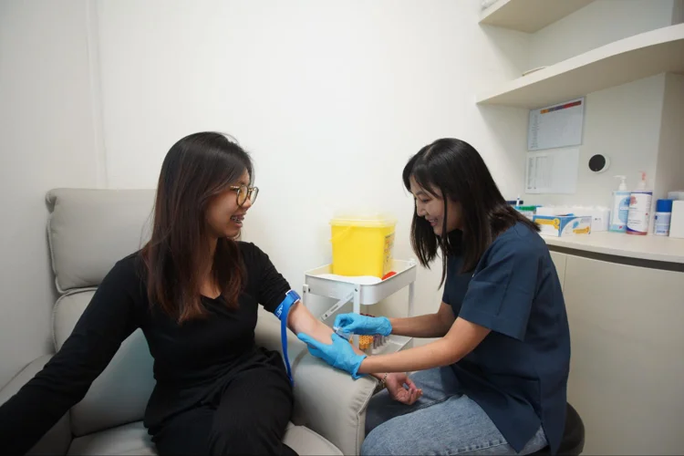 Nurse drawing blood for heart screening at the clinic