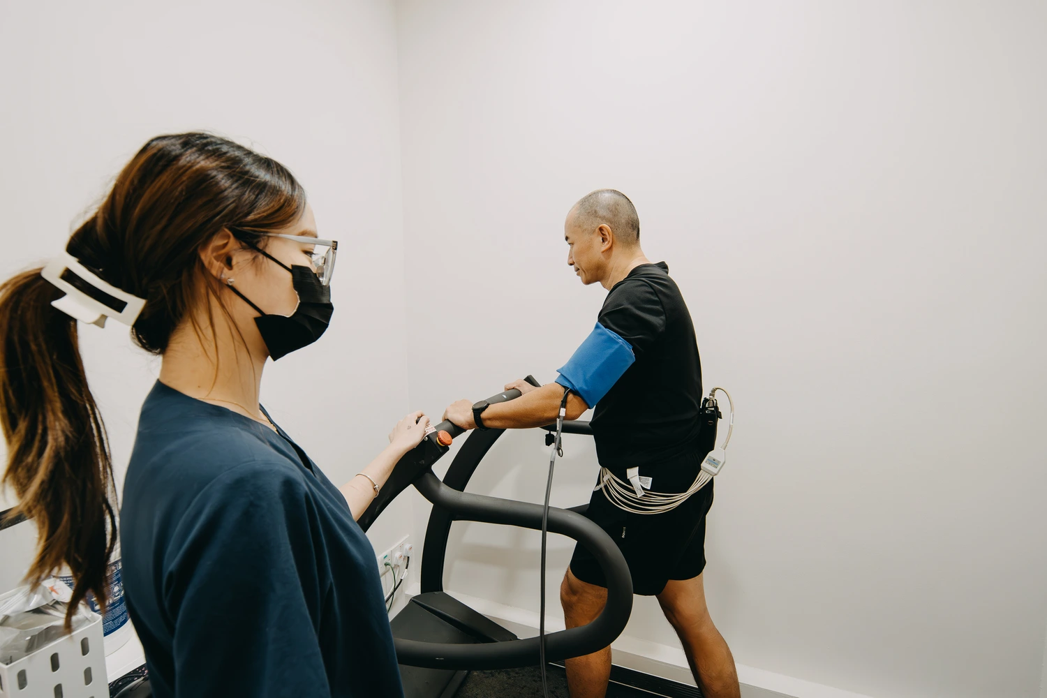 Nurse monitoring a patient during a treadmill stress test at the clinic